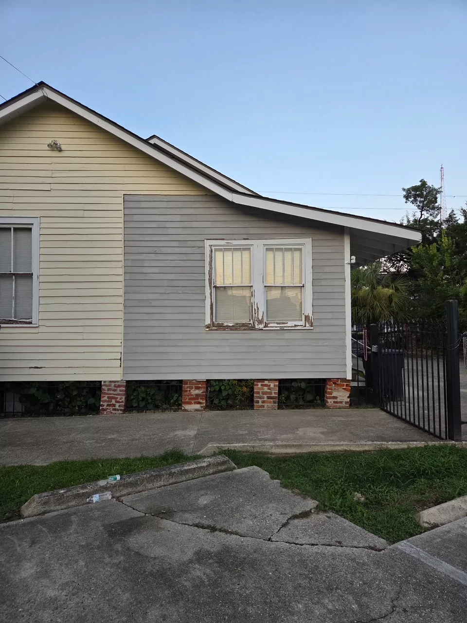 The same gable end with the wall closed back up: clapboard siding run from the brick piers to the roofline, and the double window set back in its trim.